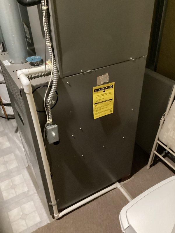 Conducted on-site assessment of existing HVAC system and water heater in 20-year-old residential property to provide replacement quotation. Inspected furnace unit located in basement utility room, noting ENERGUIDE labeling and connected PVC condensate drainage system with associated ductwork and evaporator coil assembly. Evaluated outdoor Lennox condensing unit positioned on concrete pad with refrigerant line connections to building, verifying operational configuration and installation parameters. Examined water heater unit positioned in basement corner adjacent to heating equipment. Documented existing equipment specifications, installation locations, and mechanical room layout through photographic records. Assessed accessibility for future equipment replacement, including clearance requirements, utility connections, venting configurations, and electrical service provisions. Reviewed overall system age and provided comprehensive replacement recommendations for all three units based on