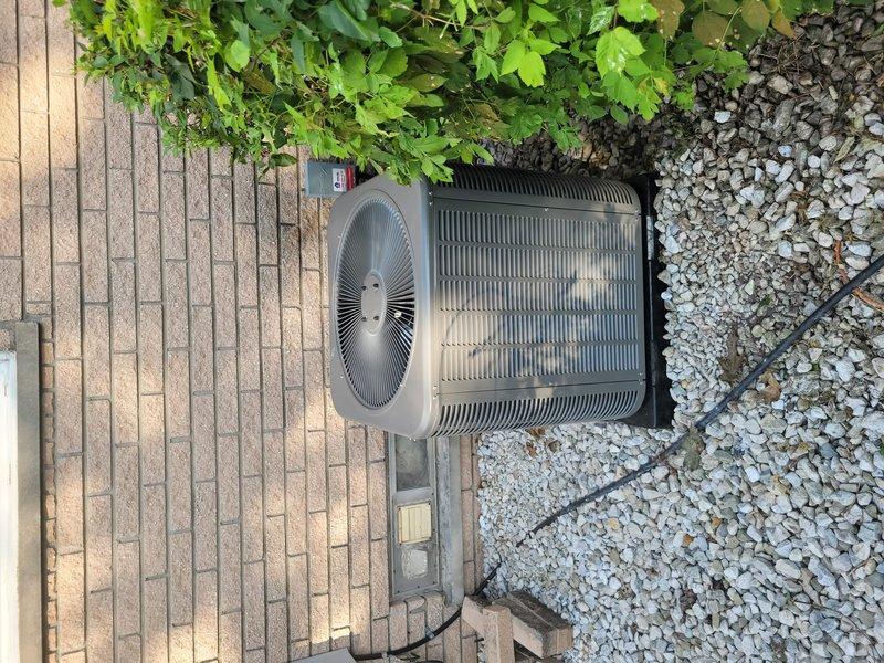 Completed full HVAC system installation including Lennox furnace, air conditioning condenser unit, and T6 programmable thermostat. The outdoor condenser was positioned on a concrete pad adjacent to the brick paver patio with proper clearances maintained from landscaping and building structure. All refrigerant lines, electrical connections, and condensate drainage piping were installed per manufacturer specifications and routed through the exterior wall using appropriate PVC fittings and weatherproof penetrations. System was tested, charged, and verified operational upon completion.