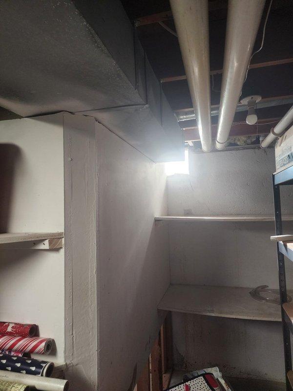 Responded to customer complaint of high-pitched noise from AC system. Upon inspection, confirmed abnormal sound emanating from air handler unit located in basement utility area. Diagnosed issue as blower motor bearing failure causing the high-pitched squealing noise. Customer had previously replaced air filter in attempt to resolve the issue, but noise persisted due to mechanical component failure rather than airflow restriction. Documented equipment condition and basement installation with photos showing ductless mini-split air handler mounted on wall and basement infrastructure including exposed joists, ductwork, and PVC piping. Recommended blower motor replacement to eliminate noise and prevent complete system failure.