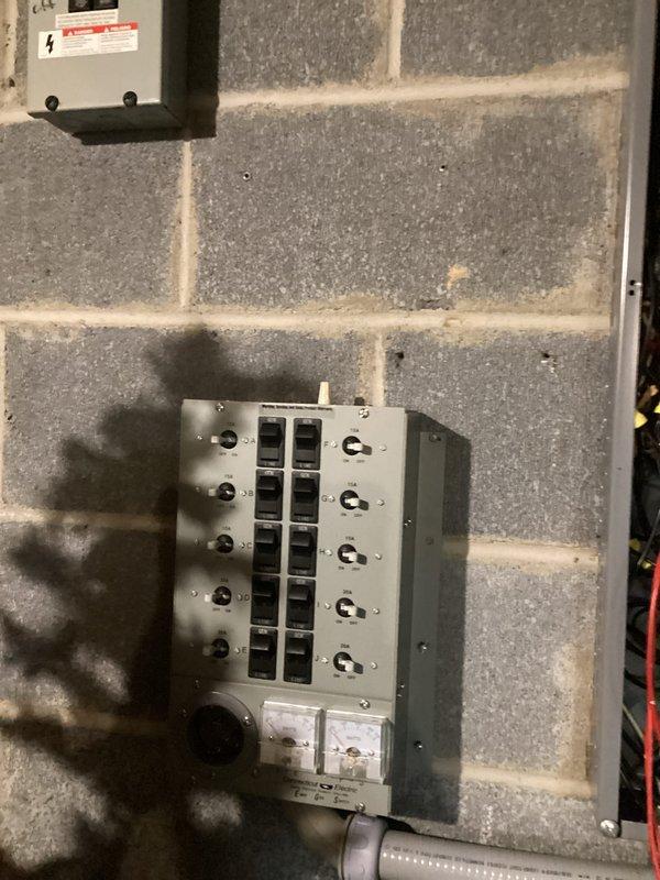 Conducted comprehensive site assessment and electrical estimate for generator installation at brick commercial building. Evaluated existing electrical infrastructure including dual meter configuration, surface-mounted conduit system, and main distribution panel with approximately 10-12 circuit positions in utility area. Documented current electrical service entrance equipment, junction boxes, and wire routing to determine optimal generator integration points and transfer switch placement requirements. Photographed exterior electrical components mounted on brick facade and interior breaker panel on concrete block wall to assess load capacity and identify necessary upgrades for automatic transfer switch installation and generator connectivity.