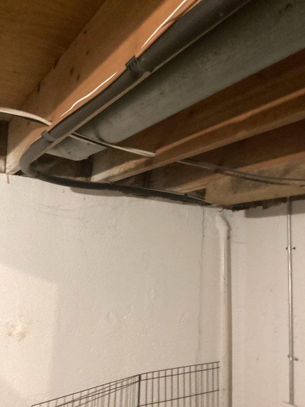 Responded to service call for 28-year-old central air conditioning system not cooling and affecting entire home. Upon arrival, inspected outdoor condensing unit manufactured in 1998 and indoor air handler unit dating to 1985, both utilizing obsolete R-22 refrigerant. Documented existing HVAC infrastructure in basement location, including aged air handler with visible corrosion and rust deterioration along panel seams and horizontal joints. Photographed gray metal ductwork, plenum assembly, and associated refrigerant lines. Noted PVC condensate drain lines and copper refrigerant piping configuration. Assessed overall system condition, confirming equipment has exceeded typical service life expectancy and operates on phased-out R-22 refrigerant, making repairs increasingly cost-prohibitive. Provided comprehensive replacement estimate for complete HVAC system upgrade to modern, energy-efficient equipment with current refrigerant technology.
