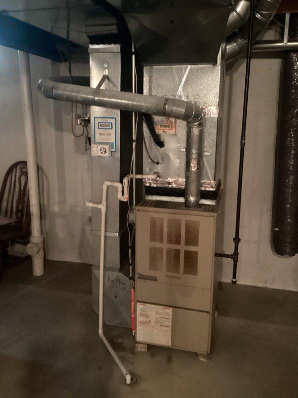 Completed comprehensive HVAC system evaluation for furnace replacement in residential basement utility space. Documented existing forced-air heating system installation, including current furnace unit condition, ductwork configuration with horizontal and vertical distribution runs, PVC condensate drainage system, venting components, and electrical connections. Assessed equipment specifications, measured installation clearances, photographed system layout and mechanical room access points to provide accurate replacement estimate and equipment sizing recommendations.