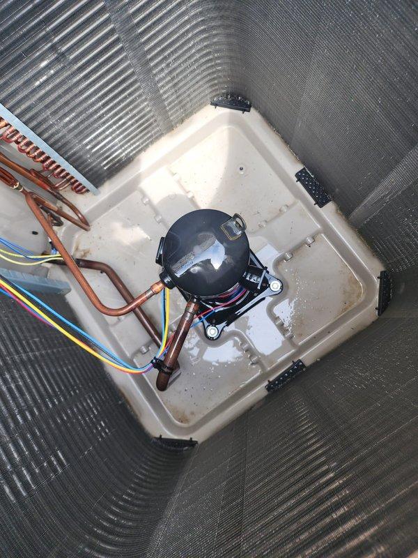 Completed comprehensive AC tune-up and maintenance on five-year-old air conditioning system. Performed thorough inspection of outdoor condensing unit including condenser coil cleaning, compressor examination, refrigerant line assessment, and electrical connection verification. Unit photographed showing clean exterior grille, properly functioning compressor with secure wiring connections, intact copper refrigerant lines, and condensate pan in serviceable condition. System operating within normal parameters with no immediate repairs required.
