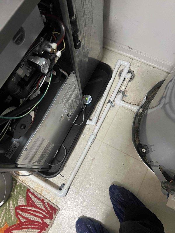 Responded to water leak service call and discovered moisture accumulation in the condensate drip pan of HVAC unit 5-9. Inspected the condensate drainage system, including PVC drain lines and connections, and documented the condition with photos showing water present in the drain pan beneath the air handler. Verified proper drain line configuration and cleared any potential blockages to restore normal condensate flow and prevent future water accumulation in the mechanical room.