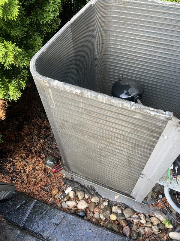 Responded to service call for AC unit leaking water. Upon arrival, inspected outdoor condenser unit and found system operational but experiencing drainage issues. Documented equipment condition showing standard residential condensing unit with weathered exterior fins and compressor assembly. Unit positioned on concrete pad with proper landscaping clearance. Verified refrigerant lines and electrical connections secure at compressor. Addressed water leakage concern and ensured proper system drainage functionality.