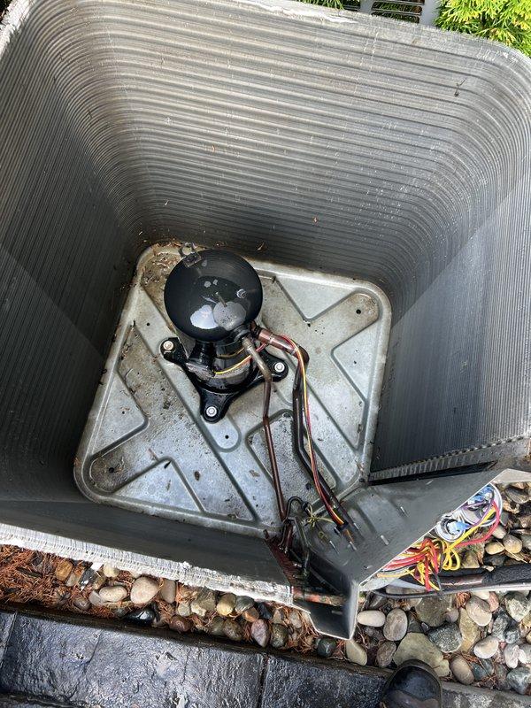 Responded to service call for AC unit leaking water. Upon arrival, inspected outdoor condenser unit and found system operational but experiencing drainage issues. Documented equipment condition showing standard residential condensing unit with weathered exterior fins and compressor assembly. Unit positioned on concrete pad with proper landscaping clearance. Verified refrigerant lines and electrical connections secure at compressor. Addressed water leakage concern and ensured proper system drainage functionality.