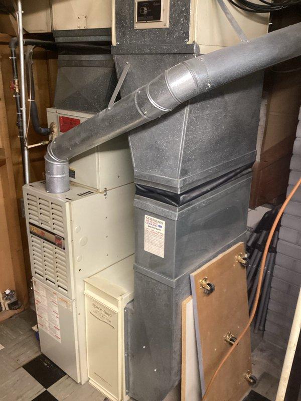 Conducted on-site evaluation for HVAC system replacement after air conditioning unit failure while furnace remained operational. Assessed existing basement installation including white furnace unit with sheet metal ductwork assembly, copper refrigerant lines, and electrical connections. Documented current equipment configuration, ductwork routing, and mechanical room layout to prepare comprehensive replacement estimate for new air conditioning system compatible with existing functional furnace.