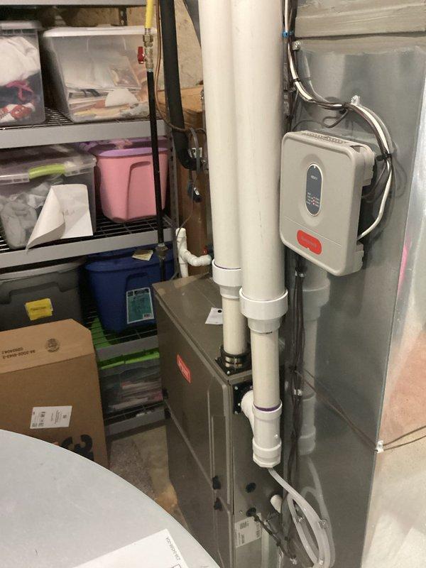 Conducted comprehensive evaluation of 16-year-old residential HVAC system for replacement estimate. Inspected indoor furnace/air handler unit located in basement utility area and outdoor condensing unit positioned on concrete pad adjacent to home's exterior. Assessed current system condition, documented existing equipment configuration including condensate drainage system and thermostat controls, and photographed both indoor and outdoor components to provide complete replacement proposal for aging climate control system.