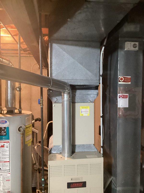 Provided comprehensive estimate for replacement of 32-year-old Lennox furnace and hot water heater located in basement utility room. Current natural gas furnace remains operational but has exceeded typical service life. Evaluated existing ductwork configuration, plenum connections, and utility room layout to determine optimal replacement specifications and installation requirements for both heating system and water heater upgrade.