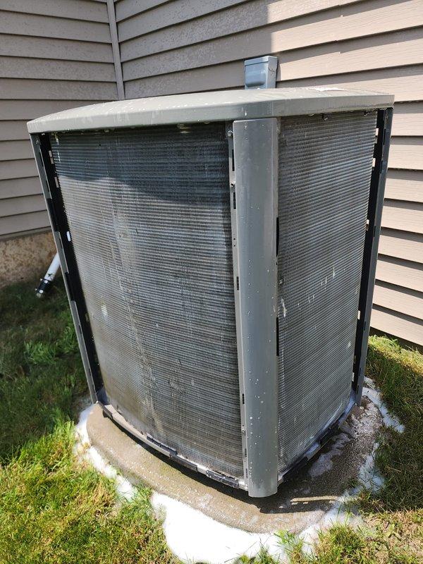 # HVAC Service Completed

Performed comprehensive tune-up on outdoor heat pump system. Upon arrival, conducted visual inspection of condenser unit positioned on concrete pad adjacent to residence. Unit appeared to be in operational condition with standard wear consistent with regular use.

Opened access panels to inspect internal components and refrigerant lines. During inspection, discovered significant frost and ice accumulation on foam-insulated suction line and accumulator, indicating potential refrigerant flow issues or low refrigerant charge. The heavy frost buildup extended along the cylindrical insulated component, suggesting the system was experiencing abnormal operating conditions.

Checked refrigerant pressures and temperatures to diagnose the cause of icing. Verified copper refrigerant lines for proper insulation and connections. Inspected condenser coil fins for cleanliness and damage—coils showed typical outdoor exposure but remained functional. Examined electrical connec