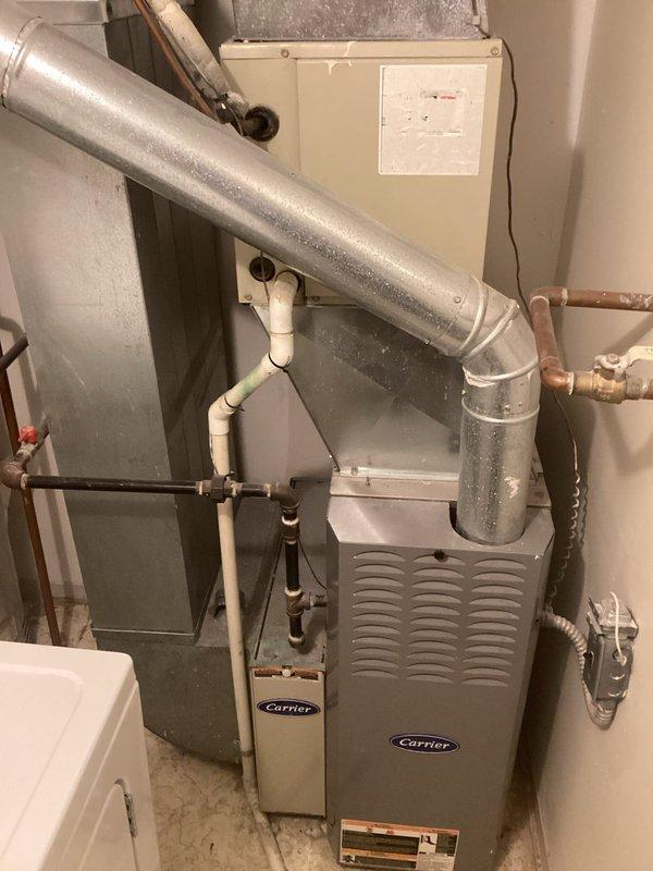 Conducted comprehensive estimate for replacement of 30-year-old residential HVAC system including existing Carrier air handler, ductwork, and associated components. Documented current equipment condition showing significant age-related wear, dust accumulation on filter housing, and evaluated existing copper refrigerant lines, PVC condensate drainage, and flexible metallic ductwork configuration in basement utility space for complete system replacement recommendations.