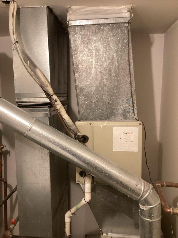 Conducted comprehensive estimate for replacement of 30-year-old residential HVAC system including existing Carrier air handler, ductwork, and associated components. Documented current equipment condition showing significant age-related wear, dust accumulation on filter housing, and evaluated existing copper refrigerant lines, PVC condensate drainage, and flexible metallic ductwork configuration in basement utility space for complete system replacement recommendations.