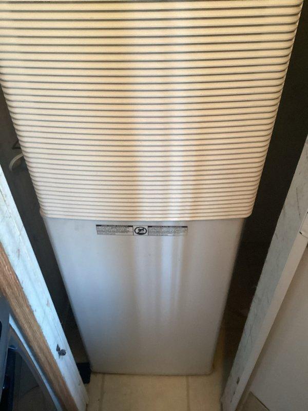 Conducted comprehensive assessment of residential air conditioning system with reported compressor failure. Upon inspection, confirmed compressor was non-operational despite recent capacitor replacement by homeowner. Evaluated complete system components, documented existing equipment specifications and installation configuration in utility closet location, and photographed unit condition including interior cabinet components, gas valve assembly, copper refrigerant lines, and condensate pan showing accumulated debris and corrosion. Provided detailed estimate for air conditioning system replacement options to restore cooling functionality.