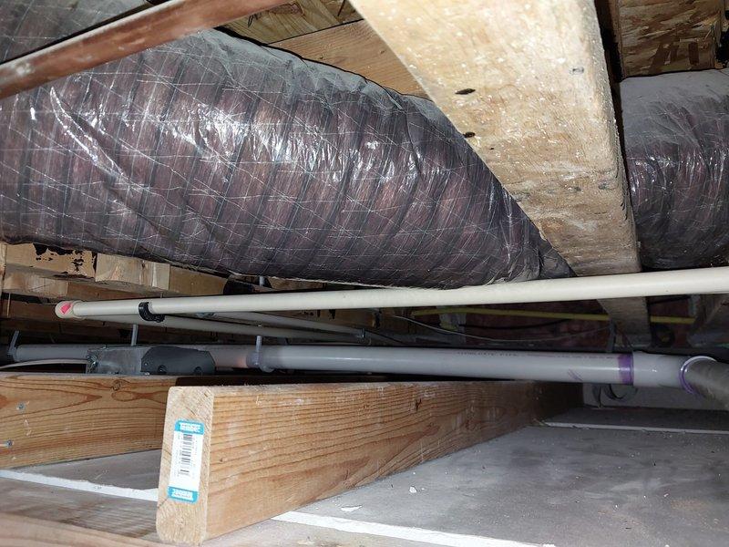 Responded to no hot water call. Upon arrival, accessed attic space to inspect tanked water heater installation. Found water heater system with associated plumbing connections including PVC piping for condensate drainage and water supply lines. Inspected installation including mounting, insulation placement around framing members, and proper venting configuration. Verified all pipe connections, supports, and hangers were secure and properly installed per code requirements. System operational upon completion of inspection and service.