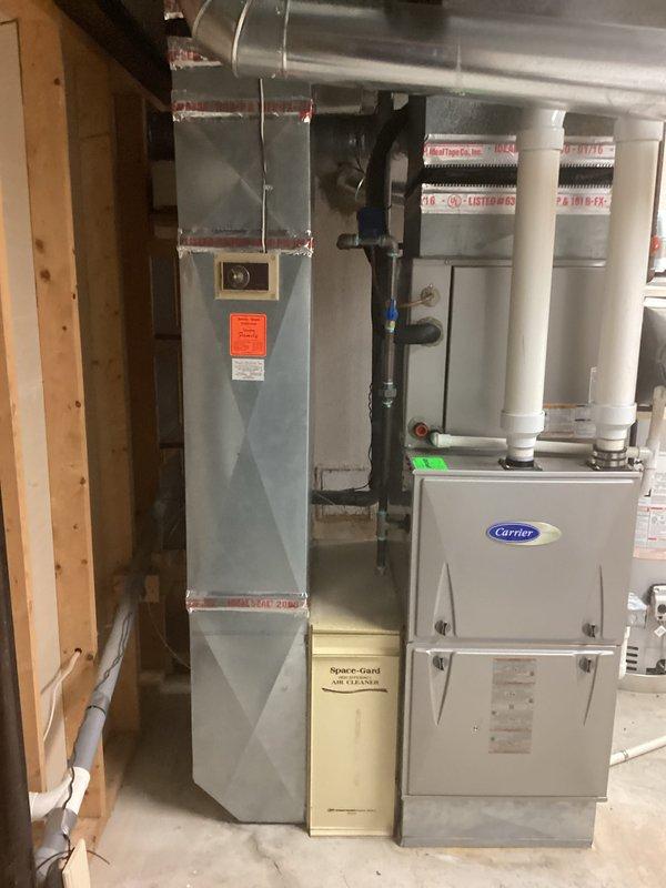 Completed comprehensive HVAC system evaluation for residential property to provide replacement estimate options. Existing system consists of Carrier outdoor condenser unit installed on concrete pad with proper electrical disconnect, paired with indoor air handler and Space-Gard air filtration system in basement. Technician documented current equipment condition, configuration, and installation setup including ductwork connections, condensate drainage, and electrical service to prepare accurate replacement proposals, as customer has been informed of pending repairs and wishes to evaluate full system replacement versus continued repair approach before peak cooling season demands.