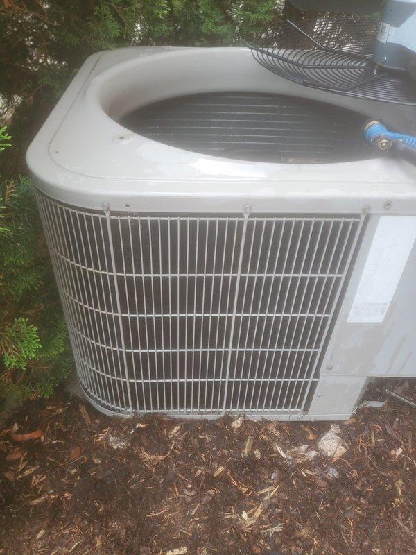 Completed annual air conditioning maintenance and tune-up on residential split system with outdoor condensing unit and basement-mounted A-coil and furnace. Performed comprehensive inspection of compressor, refrigerant lines, and condenser coil, verified proper airflow through protective grille, and checked all mechanical components for optimal operation. System found to be in good working condition with no issues identified or repairs required.