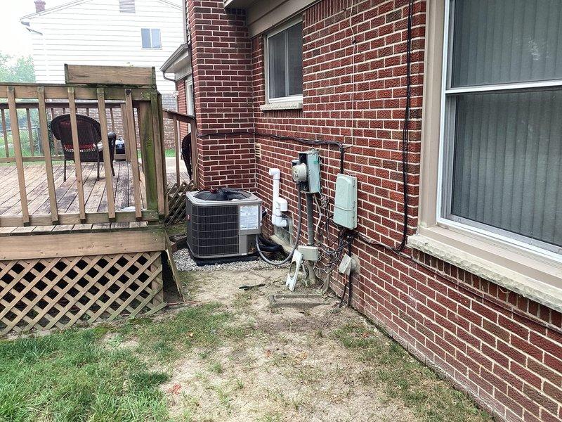 Completed warranty follow-up for failed inspection on outdoor HVAC condensing unit installation. Installed weatherproof connector from meter to disconnect and GFCI outlet at AC unit location per code requirements. Relocated and adjusted condensing unit positioning to achieve manufacturer-specified minimum clearances from brick wall foundation and adjacent structures, verified with measurements. Sealed all wall penetrations with approved fire-stop materials where refrigerant lines, electrical conduit, and drainage piping enter building envelope. Documented final installation with photographs showing proper unit clearances, compliant electrical connections, and sealed penetrations for inspection approval.