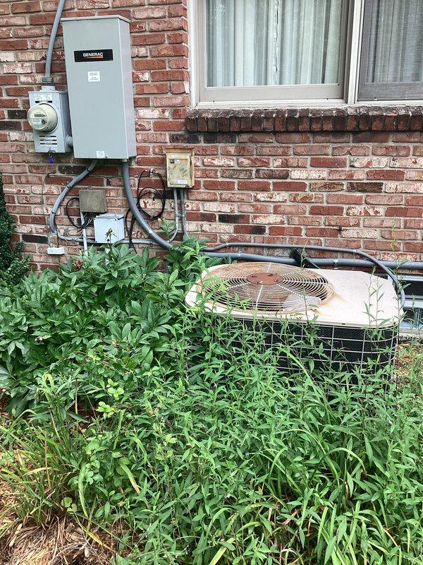 Completed comprehensive HVAC system replacement estimate for residential property. Assessed existing outdoor condensing unit showing weathering and vegetation overgrowth, along with interior Lennox furnace installation in unfinished basement space with associated ductwork, PVC venting, and refrigerant lines. Documented current system configuration including electrical infrastructure, Generac components, and overall equipment condition to provide replacement recommendations.