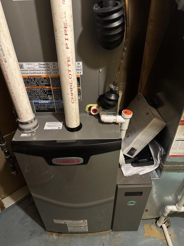 Completed full HVAC system replacement including installation of Lennox high-efficiency furnace in mechanical room with proper venting using white PVC exhaust and intake piping extending vertically through structure. Installed new Lennox air conditioning condenser unit on existing wooden deck platform with electrical disconnect box mounted to exterior siding and appropriate conduit runs. Connected gas line with shutoff valve, condensate drainage system, and all necessary ductwork transitions using flexible boot connectors. Mounted and programmed Lennox S40 smart thermostat for system control and installed Air Scrubber air purification system integrated with HVAC equipment. Verified all electrical connections, tested system operation for heating and cooling modes, confirmed proper airflow, and ensured all safety controls functioning correctly. All installations meet manufacturer specifications and local code requirements with system fully operational upon completion.