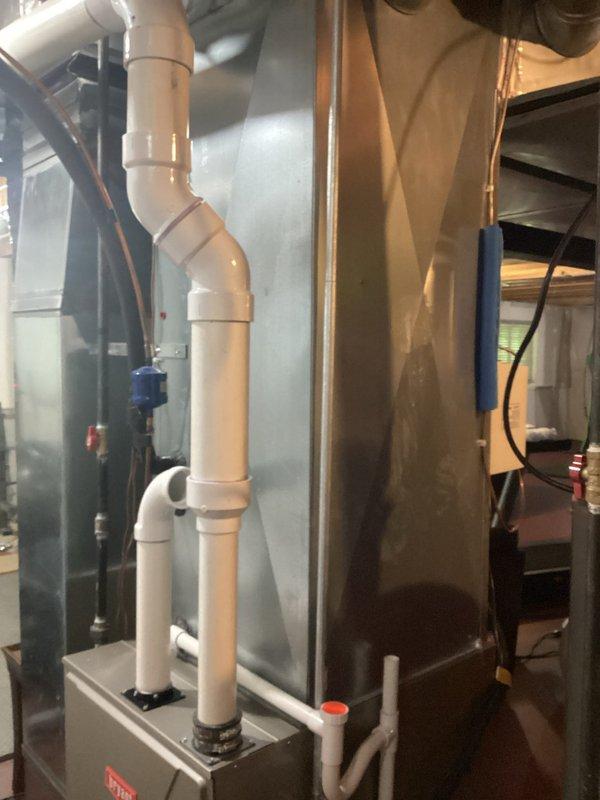 Completed air conditioning replacement estimate for residential HVAC system. Inspected existing Bryant furnace installation and associated ductwork, photographed current equipment configuration including PVC venting, copper refrigerant lines, and condensate drainage components to document baseline conditions for proposed AC system upgrade.