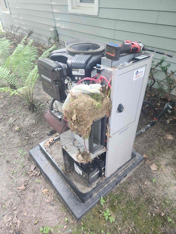 # Generator and Air Conditioning Maintenance Service

Performed comprehensive maintenance on residential standby generator equipped with Vanguard 627cc gasoline engine. Conducted visual inspection of electrical control panel, verified wiring connections, and assessed overall system integrity. Generator unit mounted on concrete pad with wooden platform base showed normal operational condition.

Completed maintenance service on outdoor split-system air conditioning unit located adjacent to generator. Upon inspection, discovered significant accumulation of dried grass, hay, and organic debris lodged within internal components between compressor and cabinet sections. Removed all foreign material obstructing airflow and mechanical components to restore proper system function and prevent potential fire hazard or equipment damage. Cleared debris from concrete pad and surrounding area.

Inspected compressor housing, fan assembly, and electrical connections on both systems. Verified proper clea