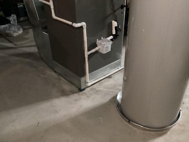 Completed installation of a 50-gallon tanked water heater in basement utility area. Unit was properly positioned on concrete floor with appropriate clearances, gas valve assembly and control module mounted and connected, and all necessary piping and venting completed per manufacturer specifications and local code requirements.