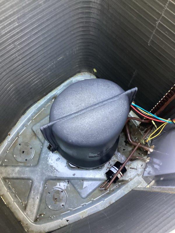 Responded to service call for central air conditioning system with reduced cooling capacity and extended run times. Upon inspection, accessed outdoor condensing unit and evaluated compressor, refrigerant lines, and electrical connections. System was still operational but performing below optimal efficiency. Documented unit condition with photos showing outdoor condenser placement and internal components including compressor housing, refrigerant lines, and electrical wiring for service records and future reference.