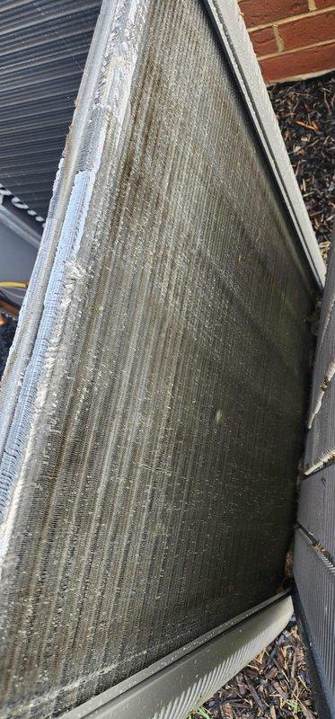 Completed annual AC tune-up on 2-year-old residential air conditioning system. Performed comprehensive maintenance inspection of outdoor condensing unit, verified compressor operation and electrical connections, and documented heavy accumulation of dirt and debris on evaporator coil fins requiring attention to maintain optimal system efficiency and airflow.