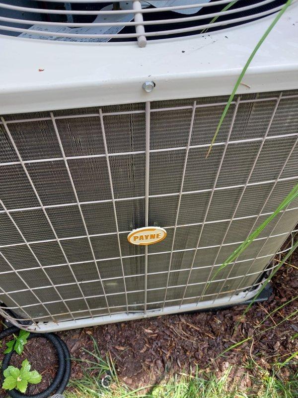Completed annual air conditioner tune-up on Payne brand outdoor condensing unit located on west side of residence. Performed comprehensive maintenance inspection including visual assessment of condenser coil condition, fan motor operation, refrigerant line integrity, and electrical connections. Inspected evaporator coil assembly and condensate drain system, noting normal moisture presence in drain pan with minor debris accumulation. All components found operating within normal parameters with no immediate service needs identified. Unit showing typical wear consistent with outdoor installation but maintaining proper function.