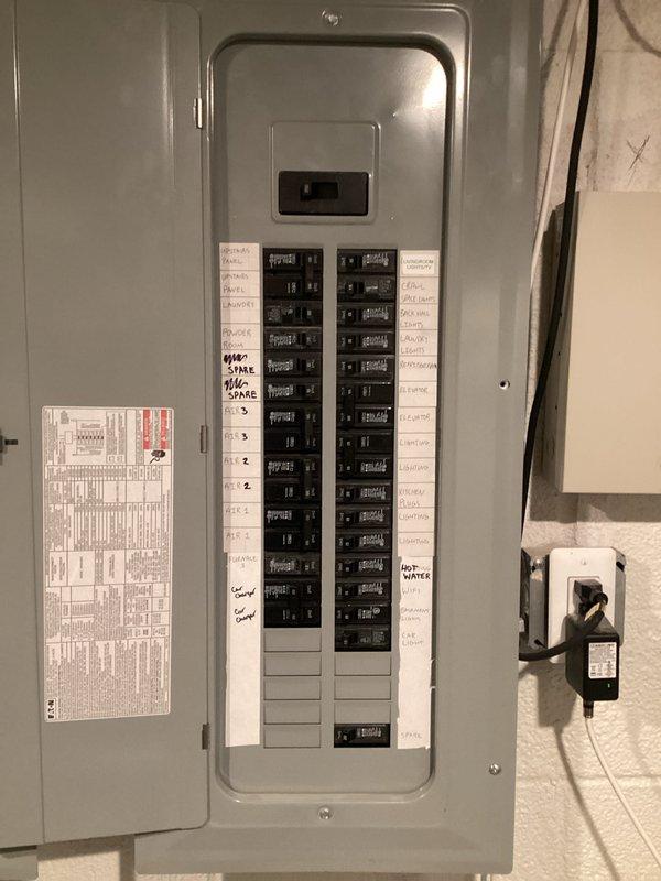 Completed electrical estimate for installation of a 2-4 person residential generator system at property currently without backup power. Assessed existing electrical panel configuration, documented circuit breaker layout and available capacity, and evaluated basement utility area for optimal generator placement and electrical integration. Photographed current electrical infrastructure including main distribution panel with labeled circuits and unfinished ceiling space showing existing copper plumbing, PVC piping, and electrical wiring runs to determine routing requirements for new generator transfer switch and connection conduits.