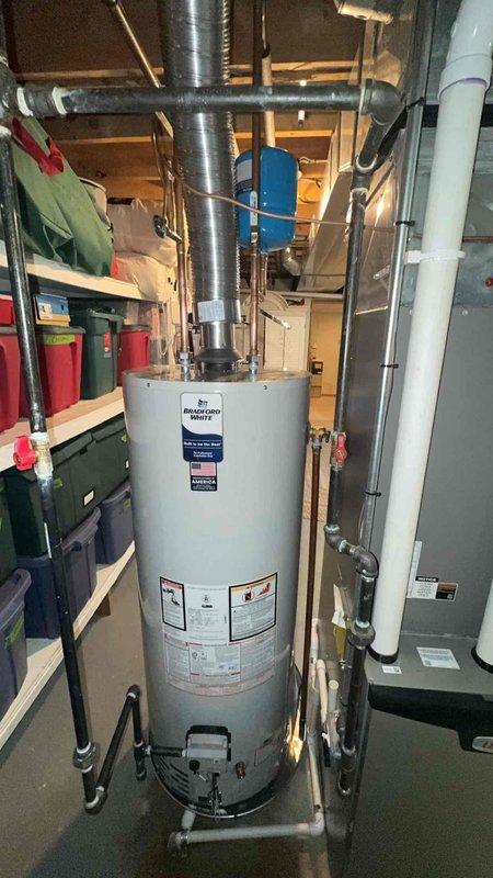 Completed installation of a 50-gallon Bradford White automatic storage water heater (Model CF53T33NS3) in basement utility area. Unit features 40,000 BTU/hr input capacity and operates on natural gas with proper venting through metal ductwork to exterior. All plumbing connections, gas lines, and electrical components were installed to code specifications, and the system was tested for proper operation and safety compliance.
