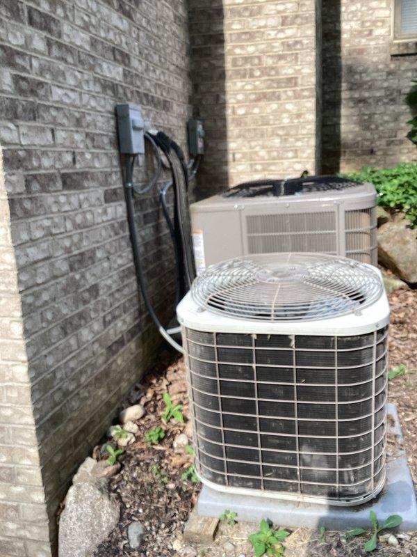 Completed comprehensive HVAC system replacement estimate for second of two residential units, with first system already successfully replaced. Site assessment documented existing cylindrical air conditioner condenser and rectangular heat pump unit positioned on concrete pad against exterior brick wall, connected via refrigerant lines and electrical conduit to wall-mounted disconnect box. Provided detailed replacement specifications and equipment recommendations to match previously installed system for consistent performance across property.