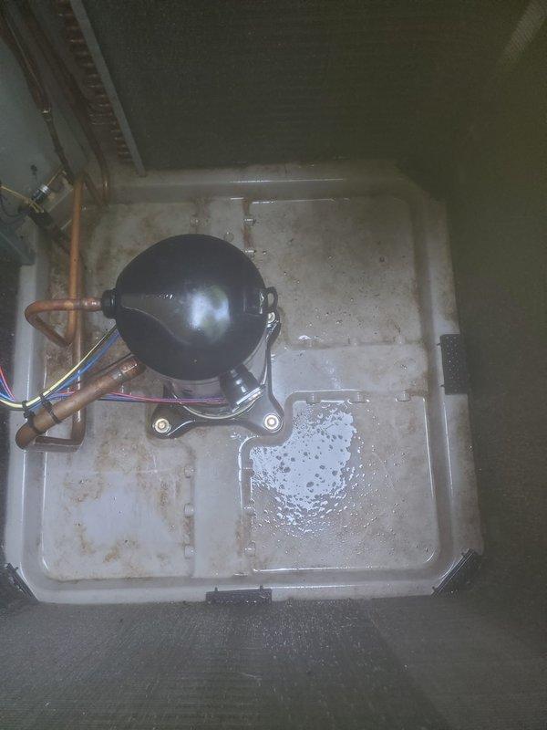 Completed scheduled cooling system maintenance and tune-up on properly functioning HVAC system. Inspected indoor compressor unit, refrigerant lines, and condensate drain pan; noted normal moisture accumulation and age-related staining in pan. Evaluated outdoor condenser unit with protective grille, verified fin condition with typical outdoor exposure and dust accumulation, and confirmed all components operating within normal parameters.