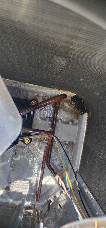 Completed routine cooling system maintenance inspection on residential air conditioning unit. Exterior condenser unit examined and photographed showing proper placement on concrete pad with adequate clearance and protective grille in good condition. Interior air handler inspection revealed significant frost accumulation on evaporator coil and refrigerant lines, indicating potential low refrigerant charge or restricted airflow issue requiring further diagnostic evaluation and corrective action to restore proper system operation.