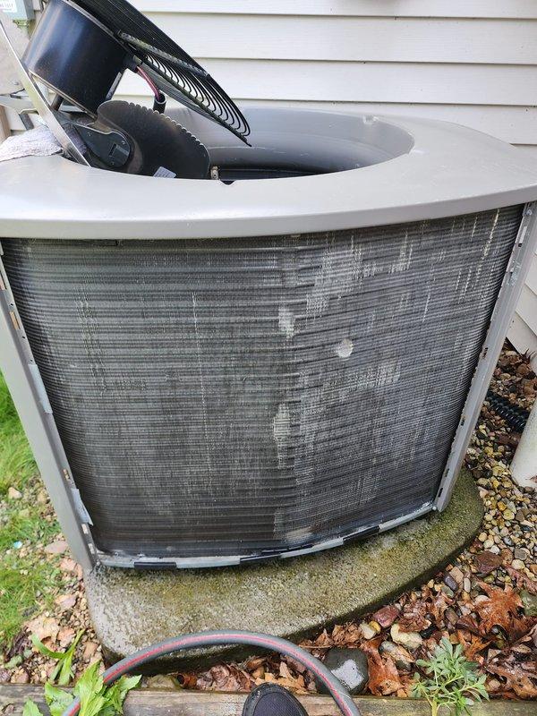 Completed preventive maintenance on residential air conditioning system. Inspected outdoor condenser unit, noting accumulated debris on protective grille which was cleaned to ensure proper airflow. Verified fan motor operation and internal components functioning normally. Inspected indoor air handler assembly, checking condensate pump, drain lines, and electrical connections for proper operation and secure mounting.