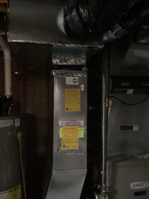 Conducted comprehensive evaluation of aging 20-year-old air conditioning system located in basement mechanical room. Assessed current air handler unit with Lennox equipment, documented existing HVAC infrastructure including ductwork distribution system, and photographed equipment condition to provide accurate replacement recommendations. System currently operational but nearing end of service life, requiring full replacement estimate for modern, energy-efficient cooling solution.