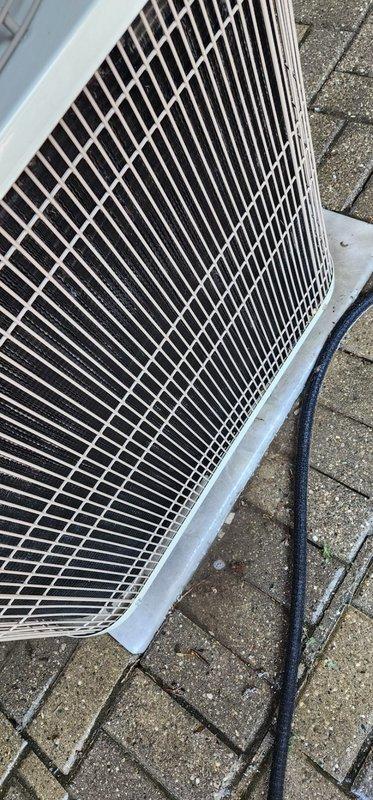 Completed routine maintenance on outdoor air conditioning condenser unit. Performed comprehensive system inspection including visual assessment of compressor, condenser coils, electrical connections, and refrigerant lines. Inspected base pan condition noting typical wear patterns and drainage function. Verified wire mesh protective grille integrity and confirmed proper airflow. Checked all electrical wiring connections and conduit routing. Unit operational and ready for continued service.