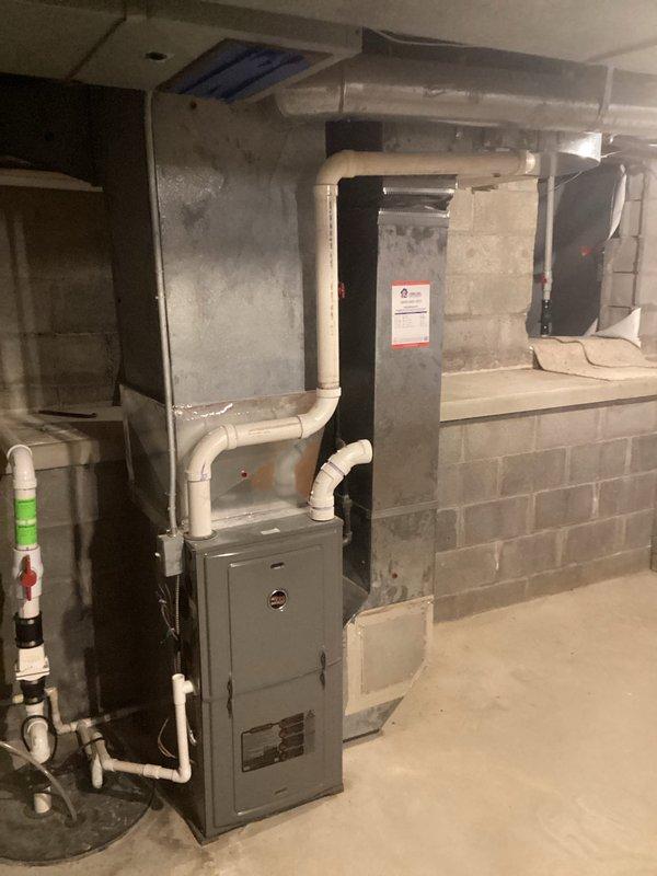 Conducted estimate for replacement of aging HVAC system in residential basement due to cracked evaporator pan causing active water leak. The existing system, over 20 years old, has discontinued parts availability, making repair unfeasible. Documented current equipment condition and installation environment, including furnace unit with connected PVC drainage piping and ductwork configuration, to provide comprehensive replacement recommendation.