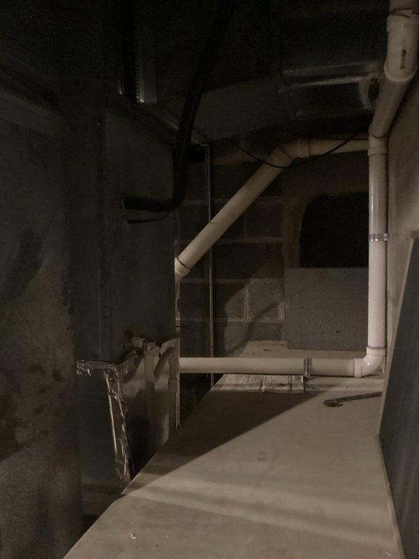Conducted estimate for replacement of aging HVAC system in residential basement due to cracked evaporator pan causing active water leak. The existing system, over 20 years old, has discontinued parts availability, making repair unfeasible. Documented current equipment condition and installation environment, including furnace unit with connected PVC drainage piping and ductwork configuration, to provide comprehensive replacement recommendation.