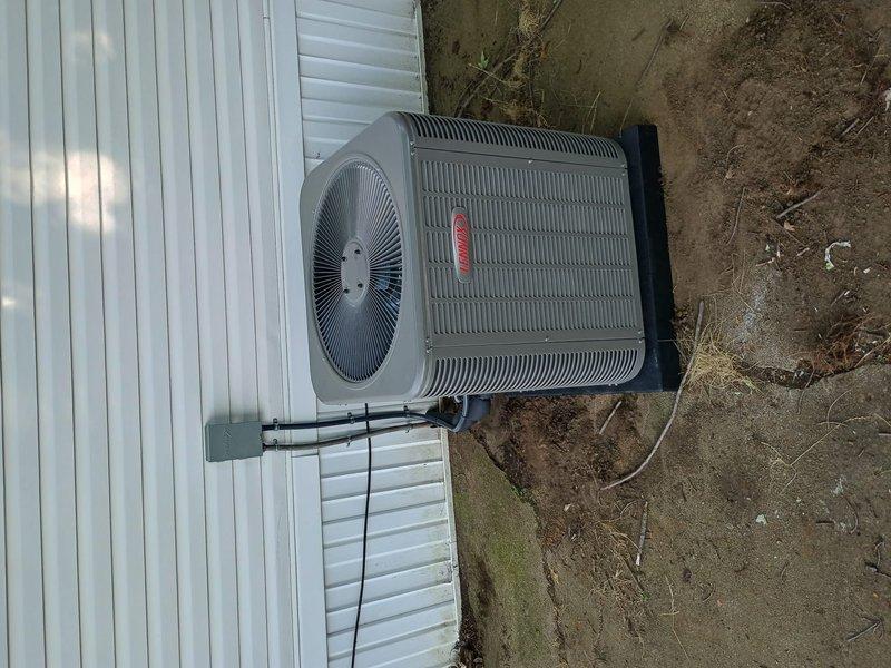 Completed full HVAC system installation at mobile home residence, including new Lennox furnace and air conditioning condenser unit. Condenser was positioned on concrete pad adjacent to structure with refrigerant lines properly routed through exterior wall. All equipment installed per manufacturer specifications and system tested for proper operation.