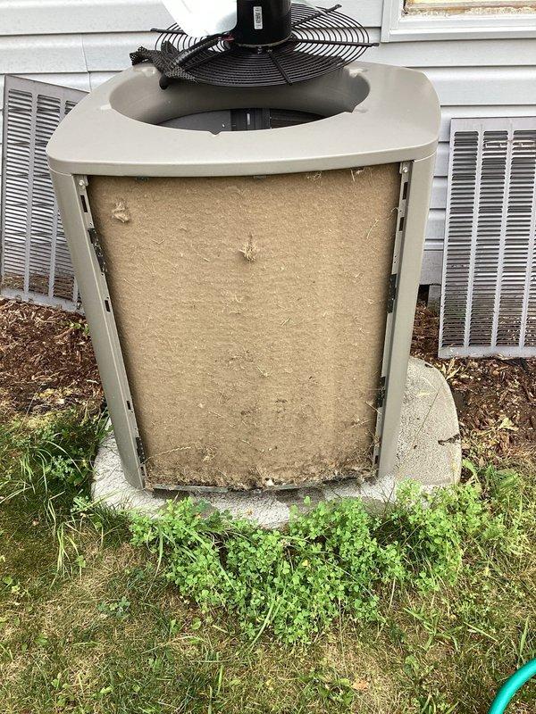 Responded to service call for air conditioning system not operating properly. Upon arrival, performed visual inspection of outdoor condensing unit and found heavily soiled filter/insulation material visible through open service panel, along with accumulated dirt and debris on unit components. Cleaned condenser coils, replaced dirty filter media, and verified proper airflow through louvered panels. Tested fan motor assembly operation and confirmed electrical connections at disconnect box were secure. System restored to normal cooling operation with improved airflow efficiency.