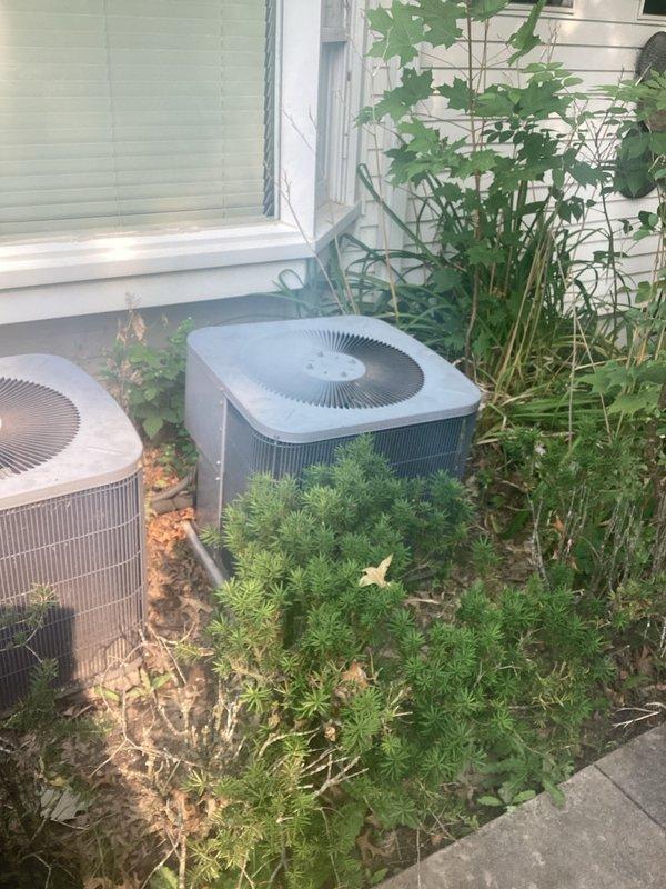 Completed estimate for replacement of two residential air conditioning systems currently operating on R-22 refrigerant. Both outdoor condenser units were inspected and found to be low on refrigerant charge. Documented existing equipment configuration including exterior-mounted condensers and attic-installed air handlers requiring ladder access and 1/4 inch nut driver for service panel entry. Photographed current system conditions and provided replacement recommendations due to refrigerant charge loss and obsolete R-22 refrigerant type.