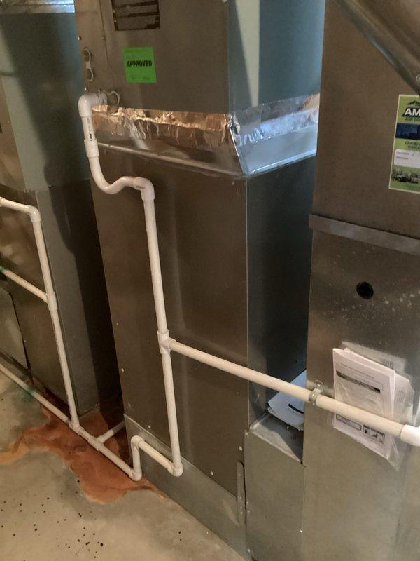 Provided comprehensive estimate for complete HVAC system replacement including outdoor condensing unit and indoor air handler due to major refrigerant leak in 13-year-old existing system that is no longer operational. Assessed current installation consisting of air handler located in basement utility area with PVC condensate drainage and outdoor unit positioned on concrete pad adjacent to brick exterior wall. Documented existing equipment configuration, electrical disconnect, ductwork connections, and drainage system to prepare detailed replacement proposal for new energy-efficient system.