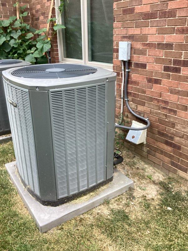 Provided comprehensive estimate for complete HVAC system replacement including outdoor condensing unit and indoor air handler due to major refrigerant leak in 13-year-old existing system that is no longer operational. Assessed current installation consisting of air handler located in basement utility area with PVC condensate drainage and outdoor unit positioned on concrete pad adjacent to brick exterior wall. Documented existing equipment configuration, electrical disconnect, ductwork connections, and drainage system to prepare detailed replacement proposal for new energy-efficient system.