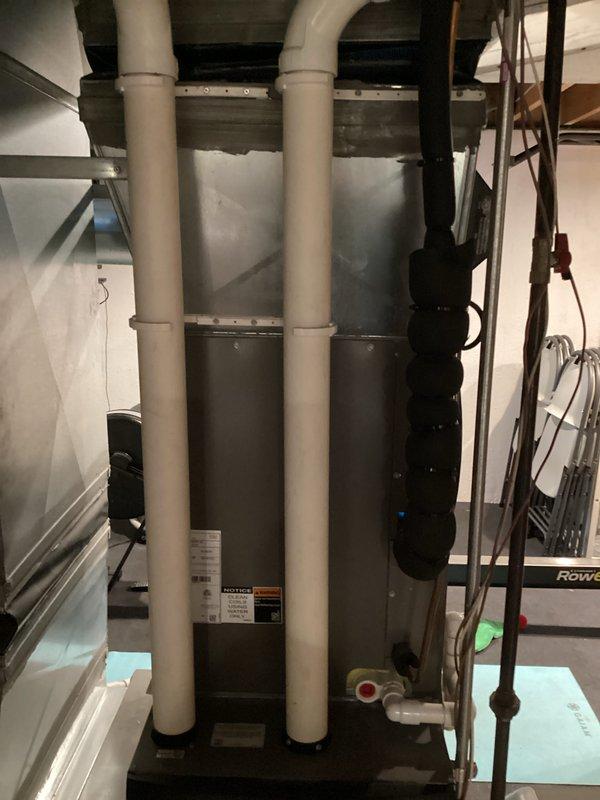 Completed comprehensive equipment replacement estimate for residential HVAC system in basement utility area. Evaluated existing Lennox furnace installation with vertical PVC venting configuration, adjacent air handler cabinet unit, and associated refrigerant lines with visible service valves. Documented current system layout including condensate drainage, electrical connections, exposed ductwork, and equipment positioning on concrete pad for replacement specifications and sizing requirements.