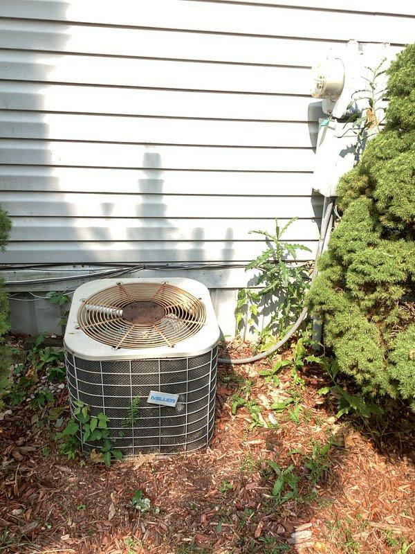 Provided comprehensive estimate for complete HVAC system replacement including both indoor furnace and outdoor air conditioning condenser unit. Existing 15-year-old system is non-operational and located in interior closet space with natural gas furnace configuration. Documented current equipment condition showing standard residential gas furnace with aging components and outdoor condenser unit with overgrown vegetation requiring clearance for proper airflow and accessibility during replacement installation.