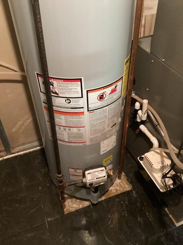 Responded to service call for residential water heater leaking from bottom of tank. Upon arrival, performed visual inspection of existing water heater installation in basement utility area. Confirmed active leak originating from base of unit, with visible water residue and mineral deposits on concrete floor surrounding tank base. Unit warranty had recently expired. Documented existing installation configuration including copper supply line connections, gas valve assembly, and condensate pump setup. Photographed current water heater condition, surrounding mechanical systems, and HVAC ductwork in overhead space for estimate preparation. Provided comprehensive assessment for water heater replacement options.