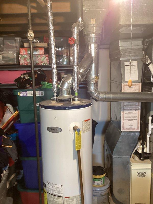 Provided estimate for replacement of existing Whirlpool hot water heater located in basement, unit over 10 years old and not functioning properly. Assessment included evaluation of current installation with gas line connection, venting system, and drip pan configuration for proper replacement specifications.