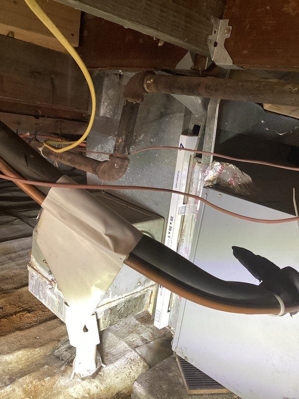 Provided comprehensive estimate for replacement of 15-year-old air conditioning system located in crawl space. Current unit is operational but nearing end of service life, with existing installation showing dust accumulation and age-related wear on metal casing and components. Evaluated existing furnace/air handler configuration positioned among floor joists with copper refrigerant lines, yellow gas line, and metal ductwork with filter assembly, noting tight clearances and accessibility constraints for future replacement work.