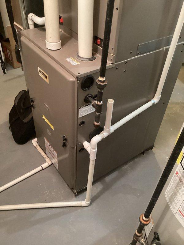 Conducted comprehensive assessment of existing HVAC system for complete replacement estimate. Documented current installation including gray furnace unit with mounted humidifier, air handler, evaporator coil assembly, and associated ductwork in basement utility area. Evaluated all system components, PVC venting and drainage lines, copper refrigerant lines with insulation, flexible ductwork connections, and control wiring. Photographed equipment specifications, piping configurations, and spatial constraints to provide accurate replacement recommendations and ensure proper sizing for new system installation.